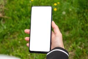 Hand holding a smartphone with blank white screen. Mockup phone. photo