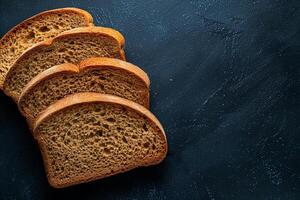Rye bread slices on a deep blue to black gradient background, highlighting the dense texture and rich color photo