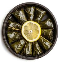 Overhead view of a Turkish stuffed grape leaves platter with lemon slices isolated on white background photo