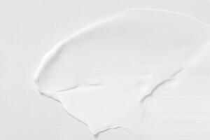 Close-up View of Thick White Cosmetic Cream Smears, Textured Background photo