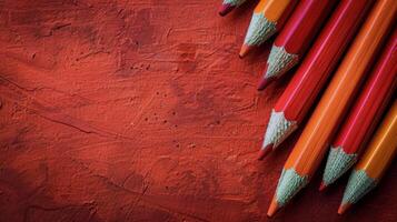Row of Colored Pencils Against Red Wall photo