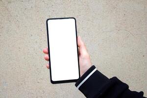 Hand holding a smartphone with blank white screen. Mockup phone. photo
