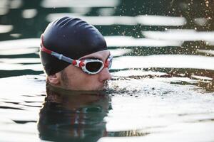 A triathlete finds serene rejuvenation in a lake, basking in the tranquility of the water after an intense training session photo