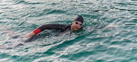 A professional triathlete trains with unwavering dedication for an upcoming competition at a lake, emanating a sense of athleticism and profound commitment to excellence. photo