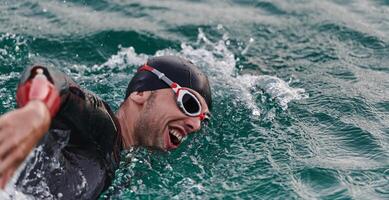 A professional triathlete trains with unwavering dedication for an upcoming competition at a lake, emanating a sense of athleticism and profound commitment to excellence. photo