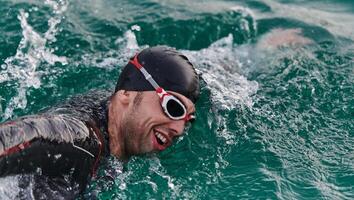 A professional triathlete trains with unwavering dedication for an upcoming competition at a lake, emanating a sense of athleticism and profound commitment to excellence. photo