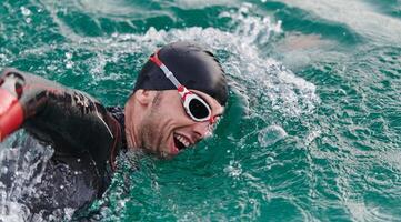 A professional triathlete trains with unwavering dedication for an upcoming competition at a lake, emanating a sense of athleticism and profound commitment to excellence. photo