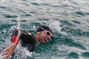 A professional triathlete trains with unwavering dedication for an upcoming competition at a lake, emanating a sense of athleticism and profound commitment to excellence. photo