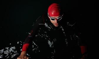 A triathlete finds serene rejuvenation in a lake, basking in the tranquility of the water after an intense training session photo