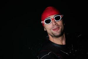 A triathlete finds serene rejuvenation in a lake, basking in the tranquility of the water after an intense training session photo