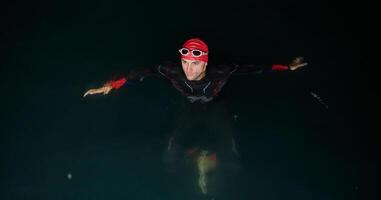 A triathlete finds serene rejuvenation in a lake, basking in the tranquility of the water after an intense training session photo