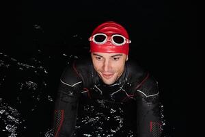 Authentic triathlete swimmer having a break during hard training on night photo