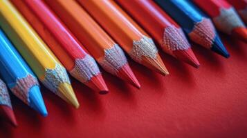 Row of Colored Pencils Against Red Wall photo