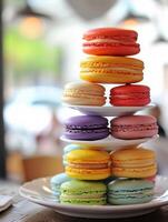 Colorful Macaron Tower on a Bright Day, A tower of brightly colored macarons stacked on a white plate, presented in a daylight-filled cafe atmosphere. photo