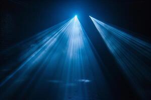 Dramatic Blue Light Rays in Dark Theater Setting photo