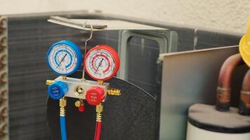 Dolly in close up shot of faulty pressure measurement device used for checking air conditioner refrigerant tank in need of fixing. Set of manifold indicators showing high or low freon levels photo