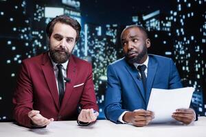 Team of presenters addressing latest news and events from around the world, discussing about newscast information regarding public interest matters. Diverse journalists night show hosts on tv. photo