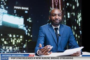 Reporter talks about new music launch, presenting successful pop star album breaking the top charts and streaming records. Night show host covering media and entertainment segment. photo