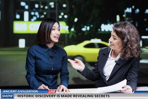 Show hosts reveal historic discovery made by specialists and experts, finding ancient civilization remains. Newscasters team debating historical disclosure on international tv program. photo