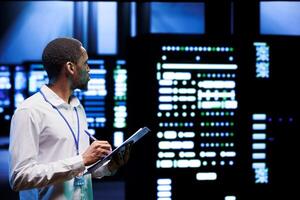 Experienced admin analyzing server systems performing data backups and providing centralized storage. Technician adjusting Uninterruptible Power Supply ensuring proper operating photo