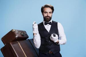 Stylish bellhop applying perfume, using strong bottle of cologne for rich luxurious scent and posing on camera. Professional doorman smelling like aromatic masculine spray, formal clothes. photo