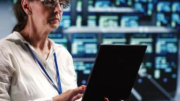 Senior technician in server room equipped to handle modern computing requirements, doing regular upgrades to components, increasing processing power and storage capacity to prevent flaws photo