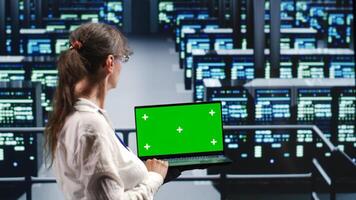 Older worker in server farm equipped to handle modern computing requirements, doing regular upgrades to infrastructure, increasing processing power and storage capacity to prevent problems photo