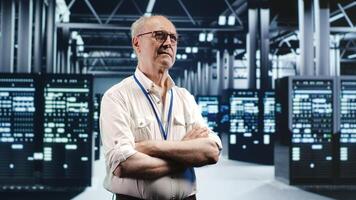Portrait of elderly engineer looking around modern server room in data center, preparing to start comission on malfunctioning high tech facility hardware rigs in order to ensure errorless operations photo