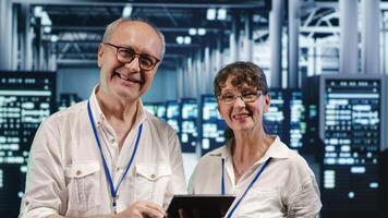 Colleagues in data center using laptop to monitor energy efficient rigs. Server farm using renewable sources employed to minimize consumption and reduce overall facility carbon footprint photo