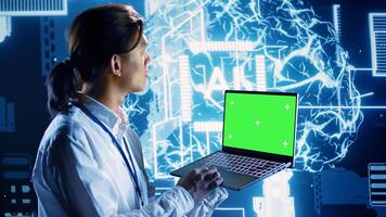 Engineer using mockup laptop to implement artificial intelligence parallel processing. Qualified administrator works on green screen device, enabling AI systems to process machine learning data photo
