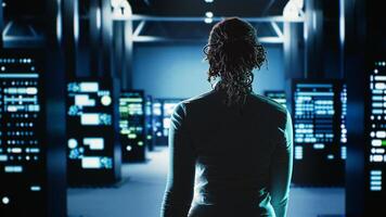 Employee walking through data center infrastructure clusters providing processing resources for different workloads. Engineer inspecting server rigs tasked with solving complex operations photo