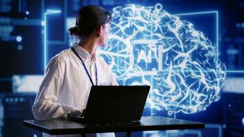 Admin using laptop to visualize artificial intelligence neural networks made up of interconnected nodes using AR holographic technology. Inspector overseeing AI systems processing information photo