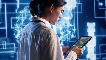 System administrator in data center running programming scripts on tablet, solving tasks. Experienced programmer manipulating lines of code for artificial intelligence applications development photo