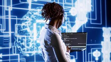 Supervisor overseeing data center updating AI systems, writing intricate binary code scripts on laptop. Knowledgeable consultant using programming to upgrade artificial intelligence simulation model photo