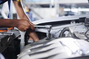 Engineer expertly examines car compressor belt using advanced mechanical tools, ensuring optimal automotive performance and safety. Skilled garage employee conducts annual vehicle checkup, close up photo