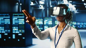 African american certified developer immersed in virtual reality at data center, doing units maintenance. Licensed technician using VR headset to optimize servers performance, checking operations photo