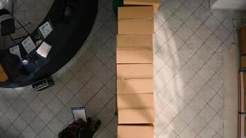 Top down view of warehouse chief supply chain officer examining cardboard box parcels in parallel, comparing findings. Depository staff members making sure stocks and inventory are well organized photo