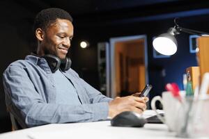 Male student sending sms online on mobile phone, attending professional training course on internet network. Young adult browsing social media sites and joining web training class program. photo