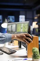 Freelancer editor working with motion graphics interface at home, grabbing headset and listening music while editing footage. Colorist videographer creating montage for post production work. photo
