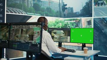 African american employee using CCTV security system and mockup screen, monitoring traffic through real time surveillance footage in observation room. Expert ensures public safety. Camera B. photo
