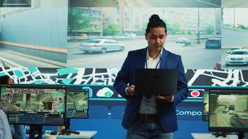 Indian team leader assigning tasks to call center operators, updating clients on parcel shipment progress. Courier agency monitoring delivery cars in traffic, satellite maps surveillance. Camera A. photo