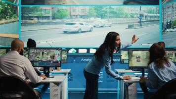 Indian supervisor leads her team to monitor the surveillance footage and CCTV cameras to learn about urban traffic dynamics. Diverse people working on public safety. Camera B. photo