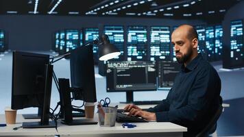 Man programming in high tech facility with server rows providing computing resources for different workloads. Admin reviewing data center supercomputers tasked with solving complex operations photo
