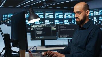 System administrator working in computer network security data center, ensuring optimal performance. Worker monitoring energy consumption across operational server racks components photo