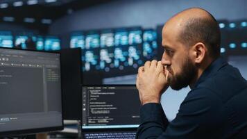 Computer scientist working in network security data center facility, ensuring optimal performance. It support employee monitoring energy consumption across operational server racks photo