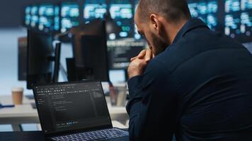 Computer scientist overseeing data center servers, typing code on laptop, troubleshooting rigs. Software professional doing maintenance on mainframes using notebook, close up shot photo