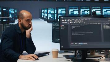 Technician using PC in high tech server hub facility to safeguard data from intruding hackers. Engineer protecting blade servers against unauthorized access, securing system from malicious traffic photo