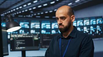 Technician coding in high tech facility with server rows providing computing resources for different workloads. Close up shot of worker overseeing supercomputers operating data photo