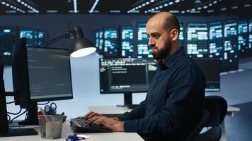 IT engineer overseeing server room, running code on computer, troubleshooting servers. Programmer at work upgrading hardware clusters, networking systems and storage arrays photo