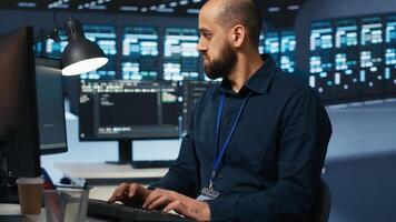 Computer scientist overseeing server hub, typing code on PC, troubleshooting rigs. Software professional doing maintenance on supercomputers, networking systems and storage arrays photo